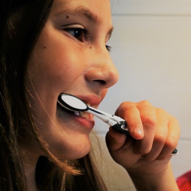 Image of girl brushing teeth from The Compounding Lab in Dayton, Ohio website.