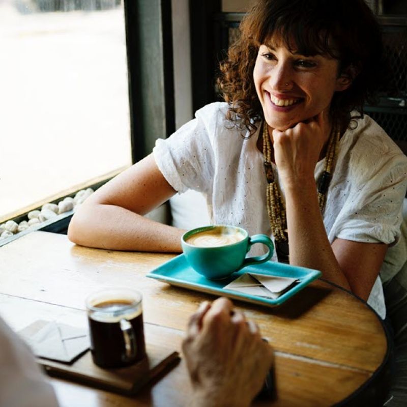 Image of woman having coffee and smiling from The Compounding Lab in Dayton, Ohio website.